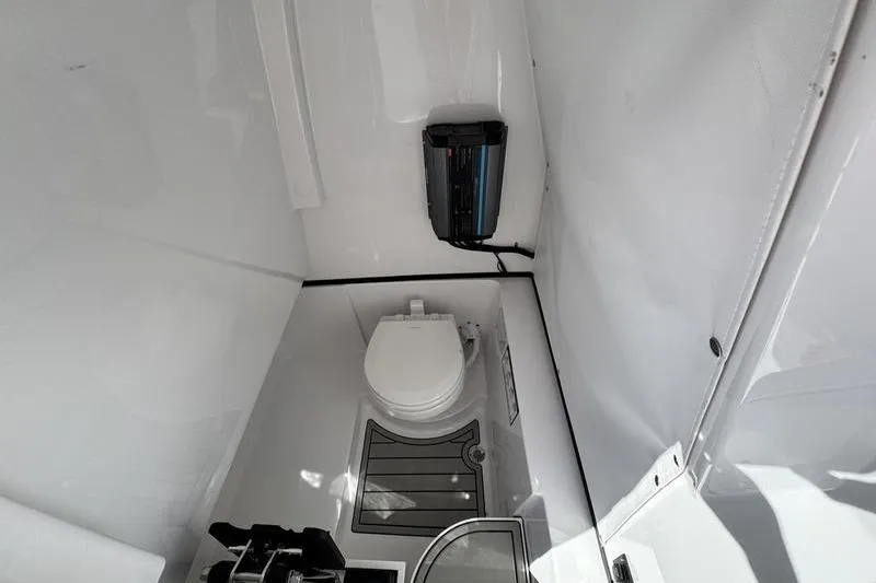 Slide: The Image of 2026 Sportsman Heritage 261 Center Console boat interior with compact marine toilet. - 19