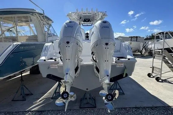 Slide: The Image of 2026 Sportsman Heritage 261 Center Console with twin 200 HP engines, docked outdoors. - 2