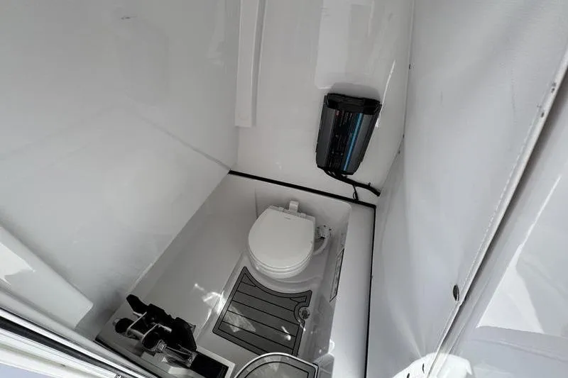 Slide: The Image of 2026 Sportsman Heritage 261 Center Console boat interior with toilet and storage. - 20