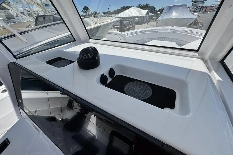 Slide: The Image of 2026 Sportsman Heritage 261 Center Console dashboard with compass and storage compartments. - 23