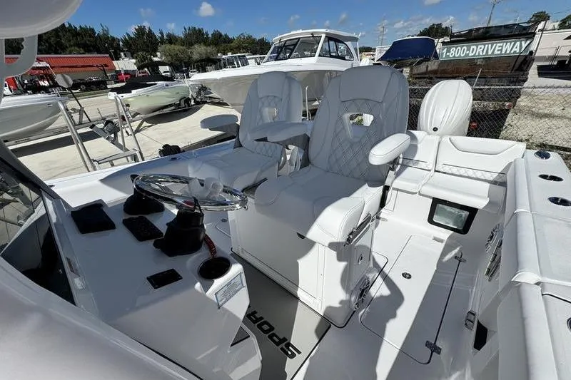 Slide: The Image of 2026 Sportsman Heritage 261 Center Console boat interior with white seating and steering wheel. - 26