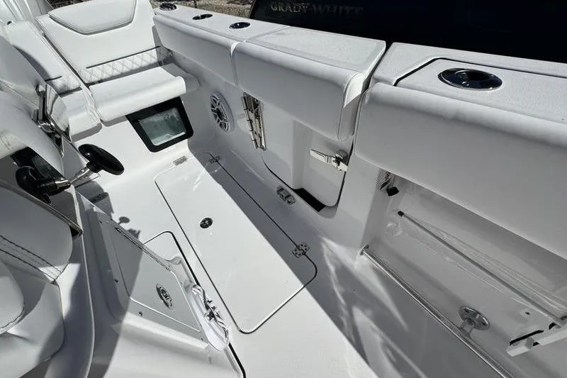Slide: The Image of 2026 Sportsman Heritage 261 Center Console boat interior with white seating and storage compartments. - 28