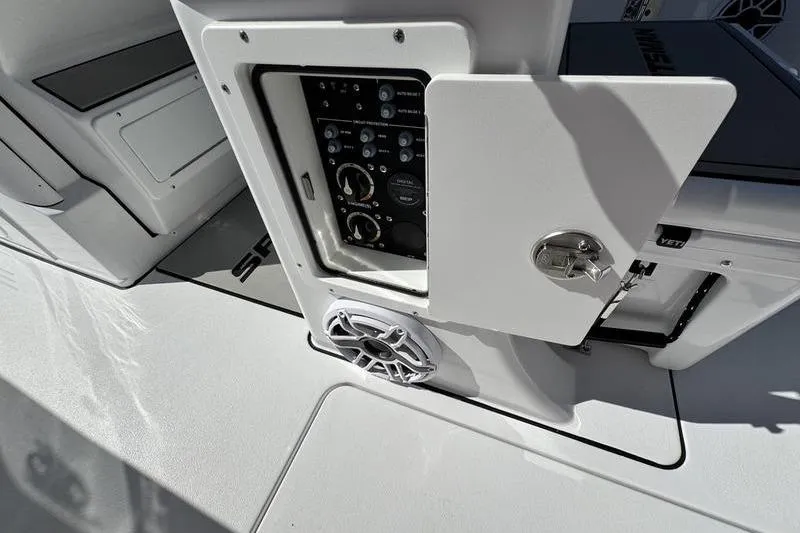 Slide: The Image of 2026 Sportsman Heritage 261 Center Console boat control panel with open compartment and speaker. - 32