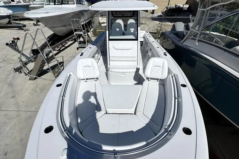 Slide: The Image of 2026 Sportsman Heritage 261 Center Console boat, docked, showcasing spacious seating and modern design. - 7