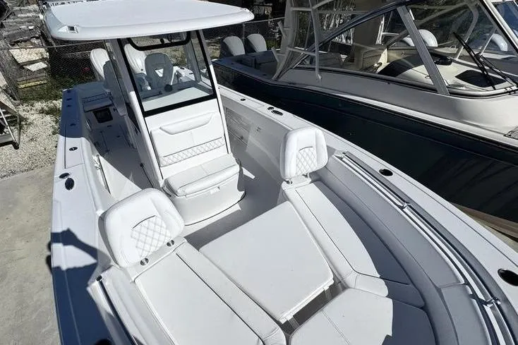 Slide: The Image of 2026 Sportsman Heritage 261 Center Console boat with sleek white seating and modern design. - 8
