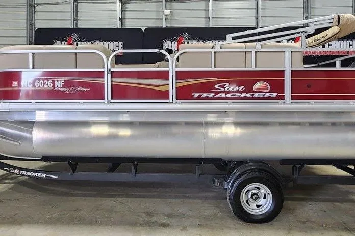 The Image of 2024 Sun Tracker Party Barge 18 DLX pontoon boat in a garage setting. - 1