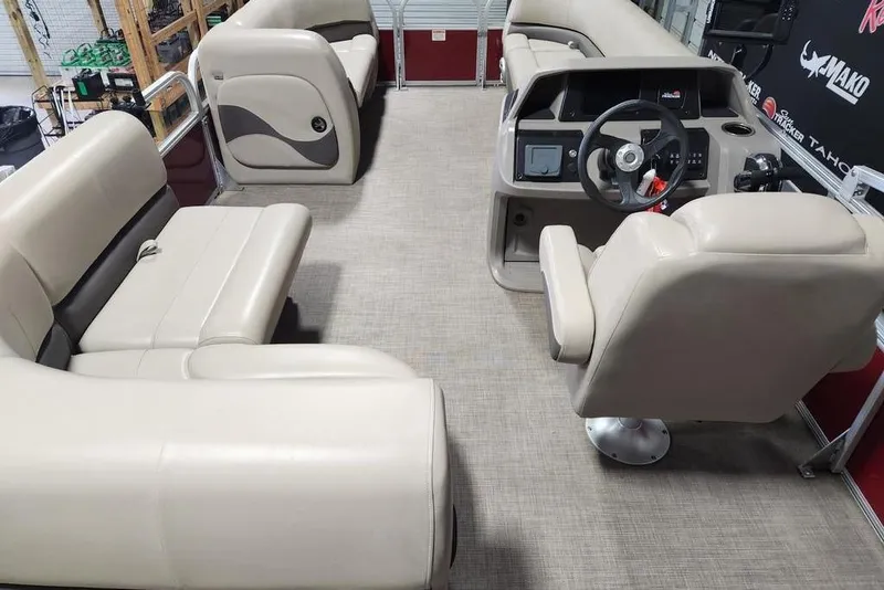 Slide: The Image of 2024 Sun Tracker Party Barge 18 DLX interior with beige seating and steering console. - 3