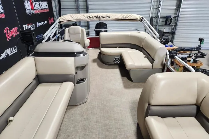 Slide: The Image of 2024 Sun Tracker Party Barge 18 DLX interior with beige seating and spacious layout. - 5