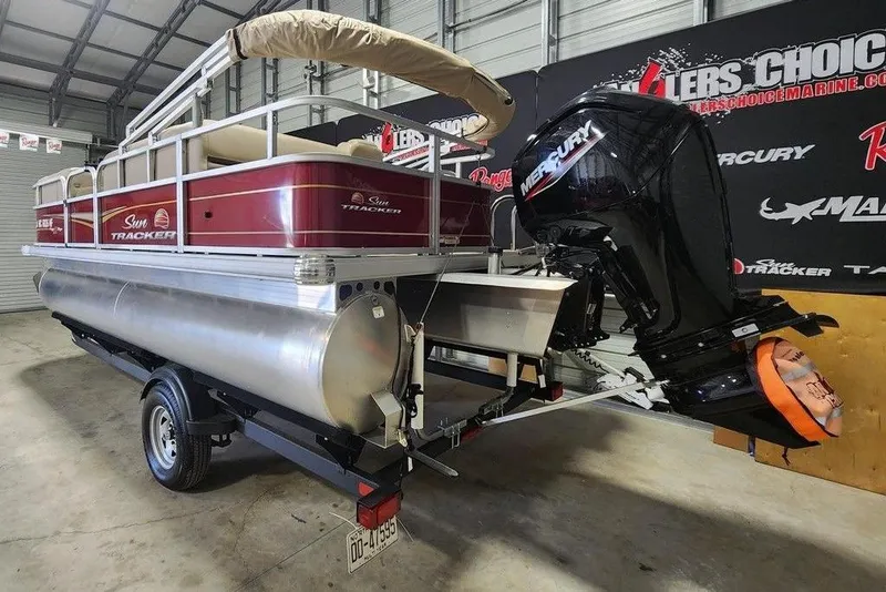 Slide: The Image of 2024 Sun Tracker Party Barge 18 DLX pontoon boat with Mercury engine in showroom. - 6