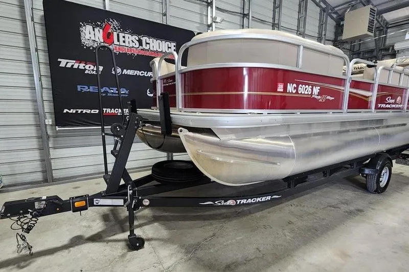 Slide: The Image of 2024 Sun Tracker Party Barge 18 DLX pontoon boat on trailer in garage. - 8