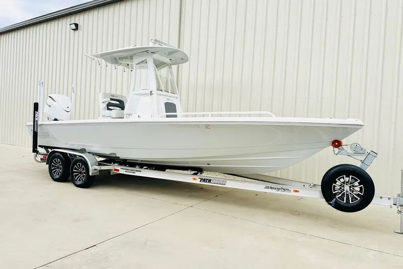 The Image of 2025 Pathfinder 2600 TRS boat on trailer, parked outside a warehouse. - 1