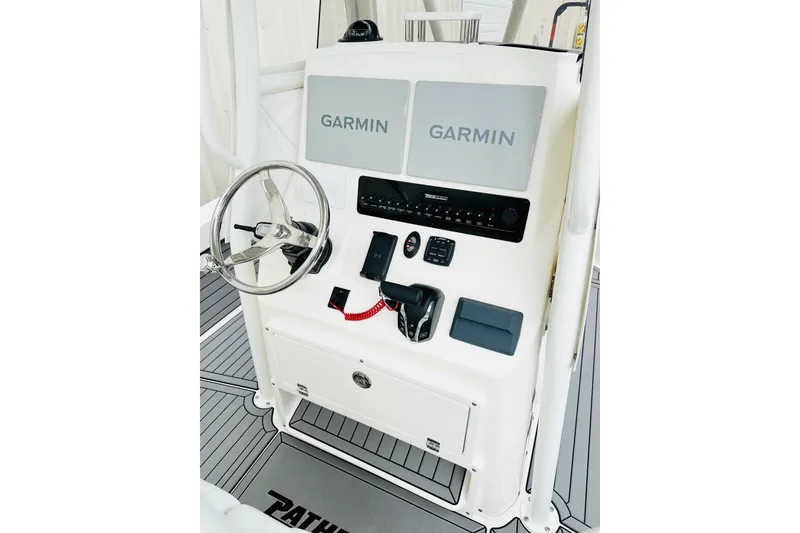 Slide: The Image of Control console of 2025 Pathfinder 2600 TRS boat with Garmin displays and steering wheel. - 2