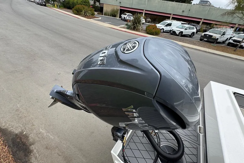 Slide: The Image of Outboard motor on a 2026 Defiance Admiral 220 EX boat, parked on a street. - 12