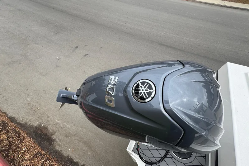 Slide: The Image of Outboard motor on a 2026 Defiance Admiral 220 EX boat, parked on a street. - 13