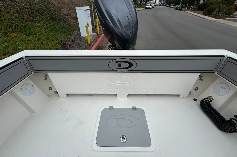 Slide: The Image of 2026 Defiance Admiral 220 EX boat interior with storage compartment and motor view. - 16