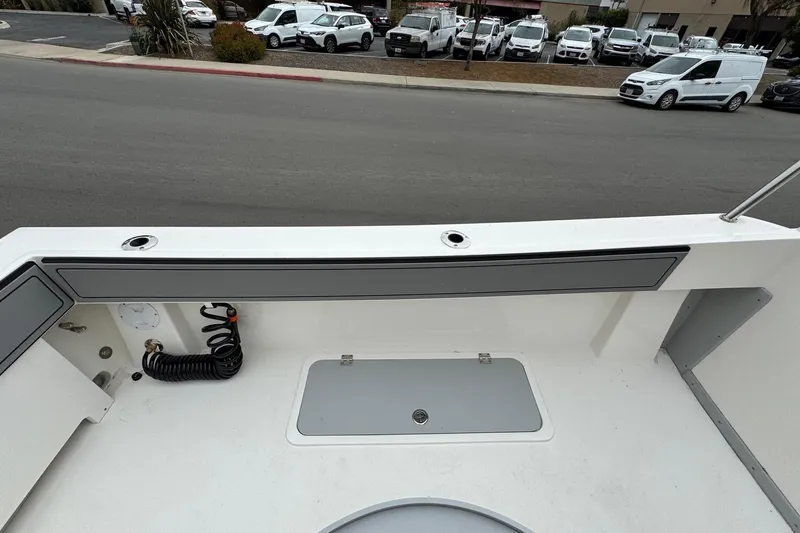Slide: The Image of 2026 Defiance Admiral 220 EX boat deck with storage and hose, parked on street. - 19