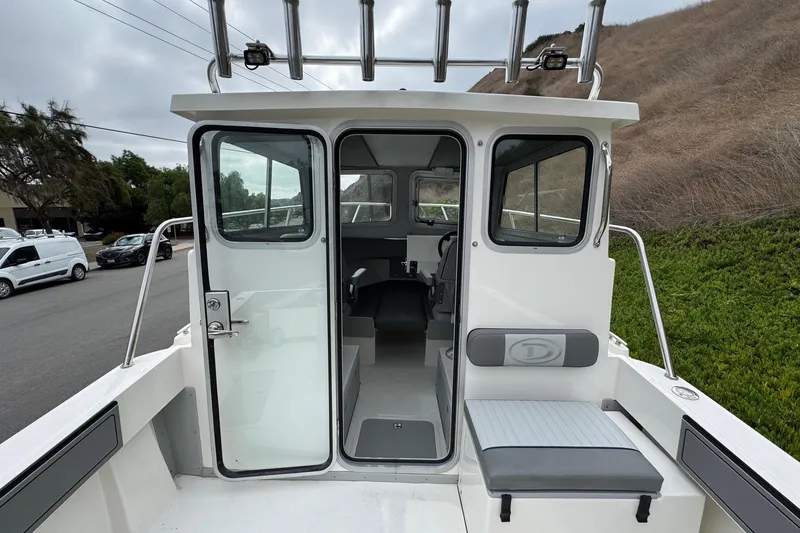 Slide: The Image of 2026 Defiance Admiral 220 EX boat interior with seating and open cabin door. - 29