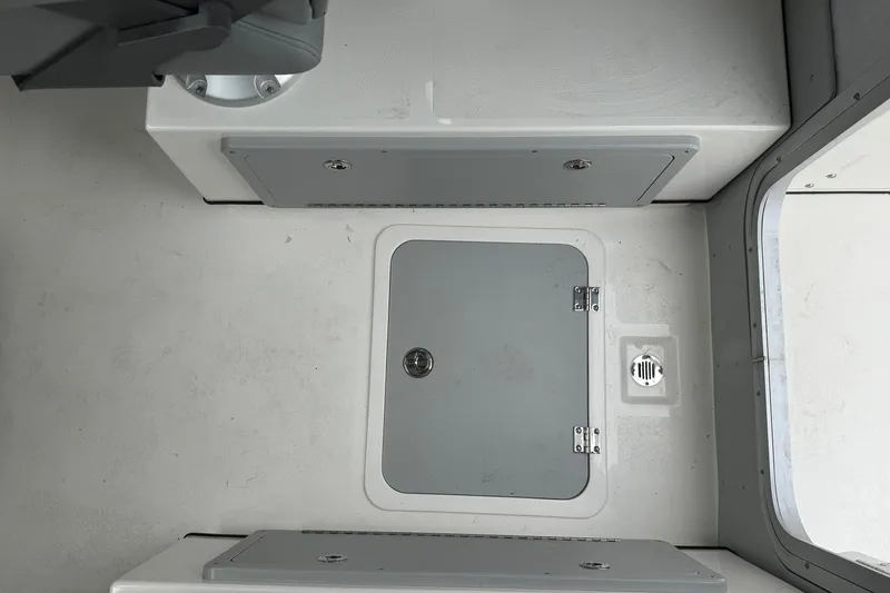 Slide: The Image of Interior view of 2026 Defiance Admiral 220 EX boat, featuring storage compartments and hatch. - 35
