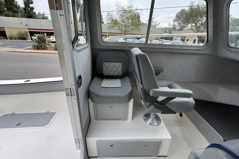 Slide: The Image of Interior of 2026 Defiance Admiral 220 EX boat, featuring gray seating and windows. - 37