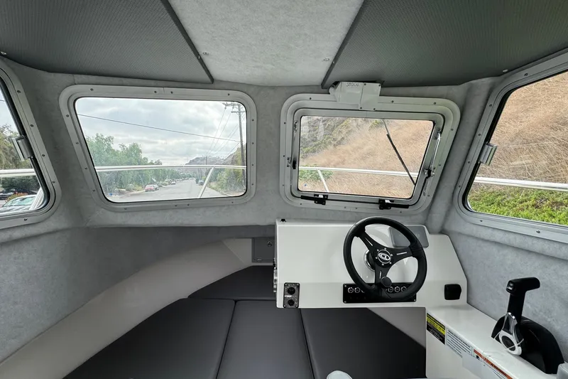 Slide: The Image of Interior view of 2026 Defiance Admiral 220 EX boat cockpit with steering wheel and windows. - 49