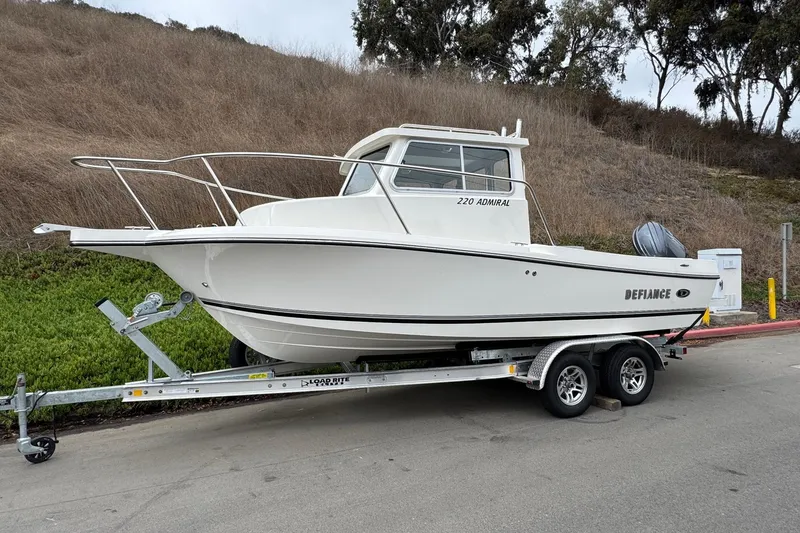 Slide: The Image of 2026 Defiance Admiral 220 EX boat on trailer, parked roadside. - 5