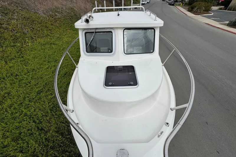 Slide: The Image of 2026 Defiance Admiral 220 EX boat on road, top view, white exterior. - 64
