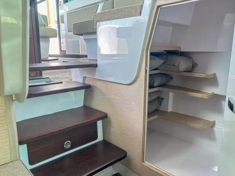 Slide: The Image of Interior of 2024 Axopar 45 XC Cross Cabin with wooden steps and storage shelves. - 14