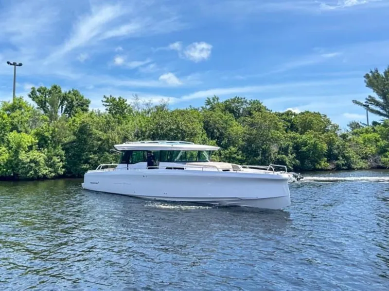 Slide: The Image of 2024 Axopar 45 XC Cross Cabin boat cruising on a scenic waterway. - 3