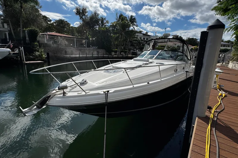 Slide: The Image of 2006 Sea Ray 340 Sundancer yacht docked by a wooden pier, under a partly cloudy sky. - 11