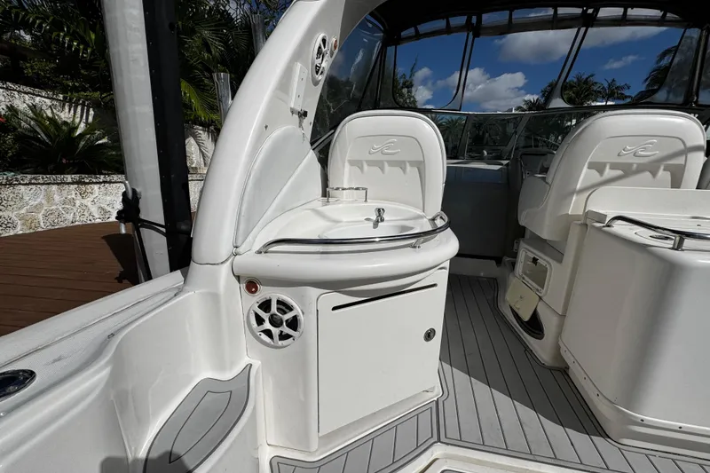 Slide: The Image of 2006 Sea Ray 340 Sundancer cockpit with seating and sink, featuring sleek white design. - 18