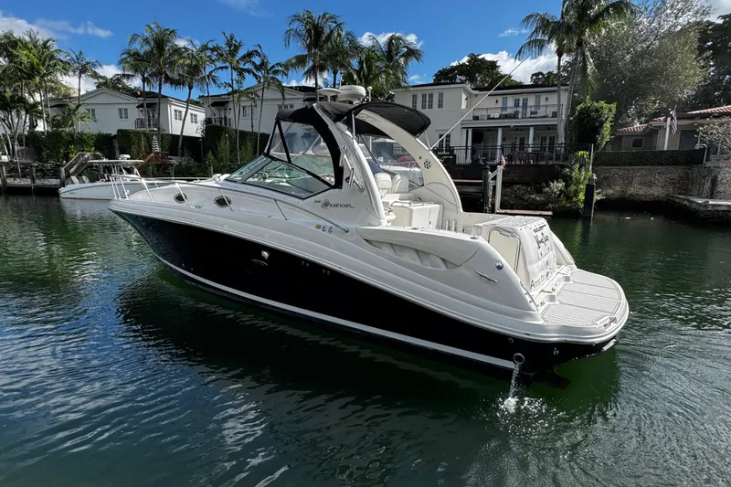 Slide: The Image of 2006 Sea Ray 340 Sundancer yacht docked in a scenic waterfront setting. - 2