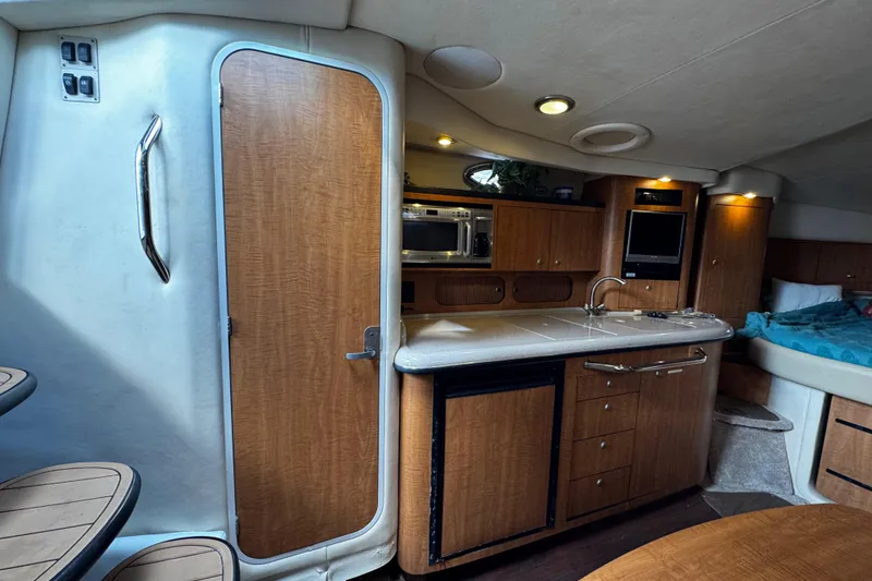 Slide: The Image of Interior of a 2006 Sea Ray 340 Sundancer yacht with kitchenette and cozy sleeping area. - 33