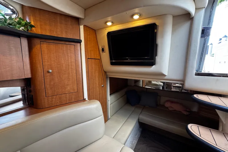 Slide: The Image of Interior of 2006 Sea Ray 340 Sundancer with cozy seating, TV, and wooden cabinetry. - 42