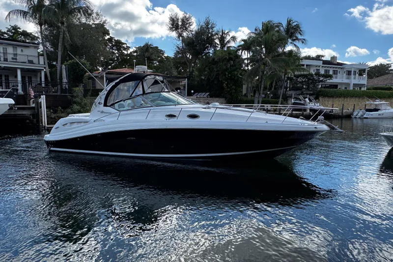 Slide: The Image of 2006 Sea Ray 340 Sundancer yacht docked in a scenic waterfront setting. - 5