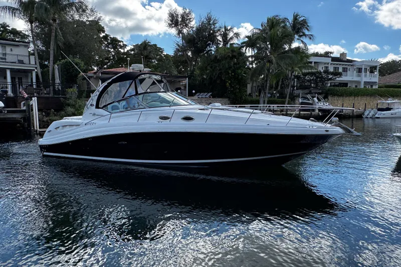 Slide: The Image of 2006 Sea Ray 340 Sundancer yacht docked in a scenic waterfront setting. - 6