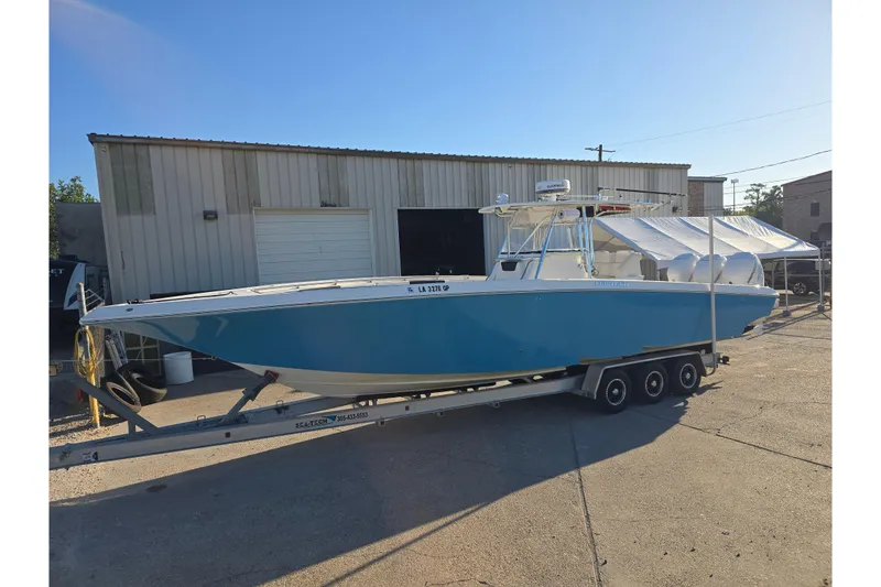 Slide: The Image of 2012 Fountain 38 Center Console boat on trailer, parked outside a warehouse. - 11