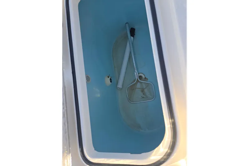 Slide: The Image of Livewell with net and handle inside a 2012 Fountain 38 Center Console boat. - 22