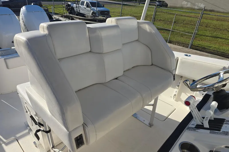 Slide: The Image of 2012 Fountain 38 Center Console boat with white cushioned seating and steering wheel. - 24