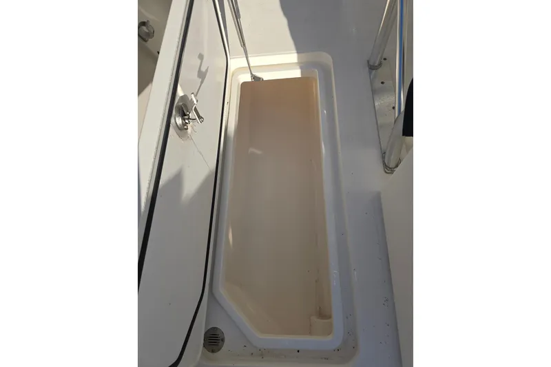 Slide: The Image of 2012 Fountain 38 Center Console storage compartment, open and empty, with stainless steel latch. - 27