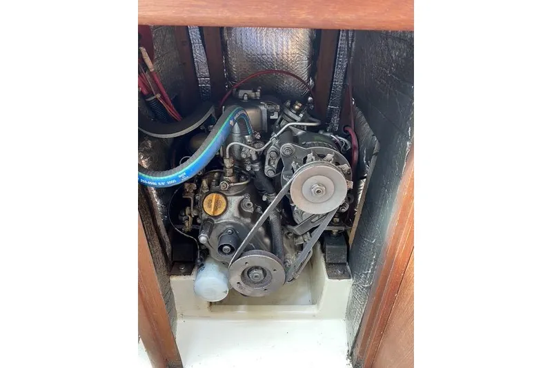 Slide: The Image of Engine compartment of a 1990 Hunter 27 sailboat, showcasing mechanical components. - 15