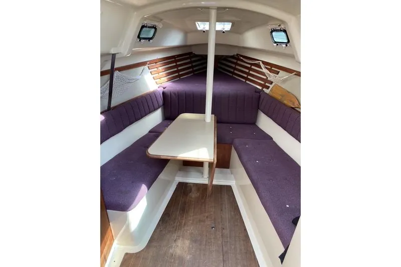 Slide: The Image of Interior of a 1990 Hunter 27 sailboat with purple seating and wooden accents. - 18