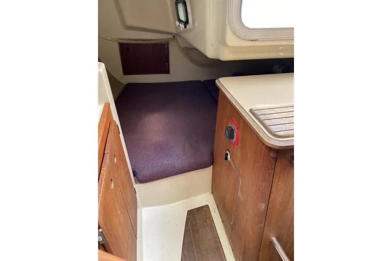 Slide: The Image of Interior of 1990 Hunter 27 sailboat with wooden cabinetry and cozy sleeping area. - 19