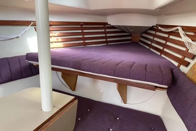 Slide: The Image of Interior of a 1990 Hunter 27 sailboat with purple cushions and wooden accents. - 24