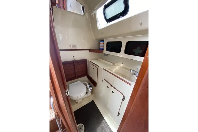 Slide: The Image of 1990 Hunter 27 sailboat bathroom with toilet, sink, and storage cabinets. - 6
