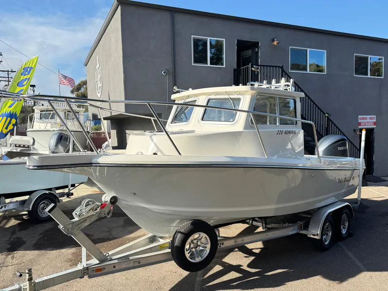 Slide: The Image of 2025 Defiance Admiral 220 EX boat on trailer, parked outside a building. - 12
