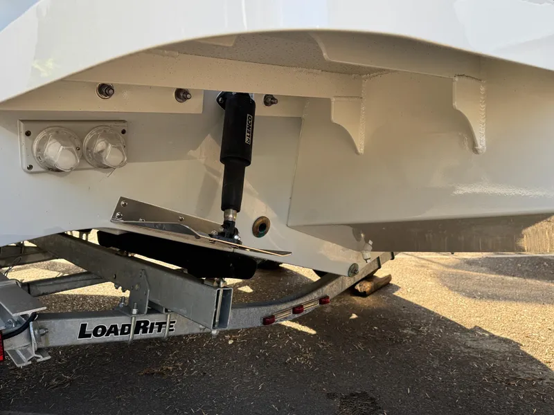 Slide: The Image of 2025 Defiance Admiral 220 EX boat on Load Rite trailer, showing trim tab and hull details. - 14