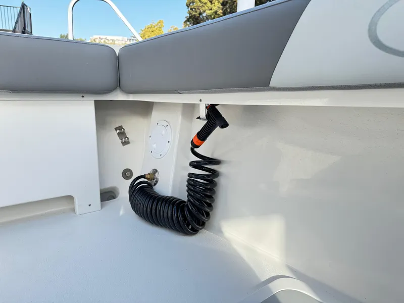 Slide: The Image of Interior view of 2025 Defiance Admiral 220 EX boat, featuring coiled hose and seating area. - 23