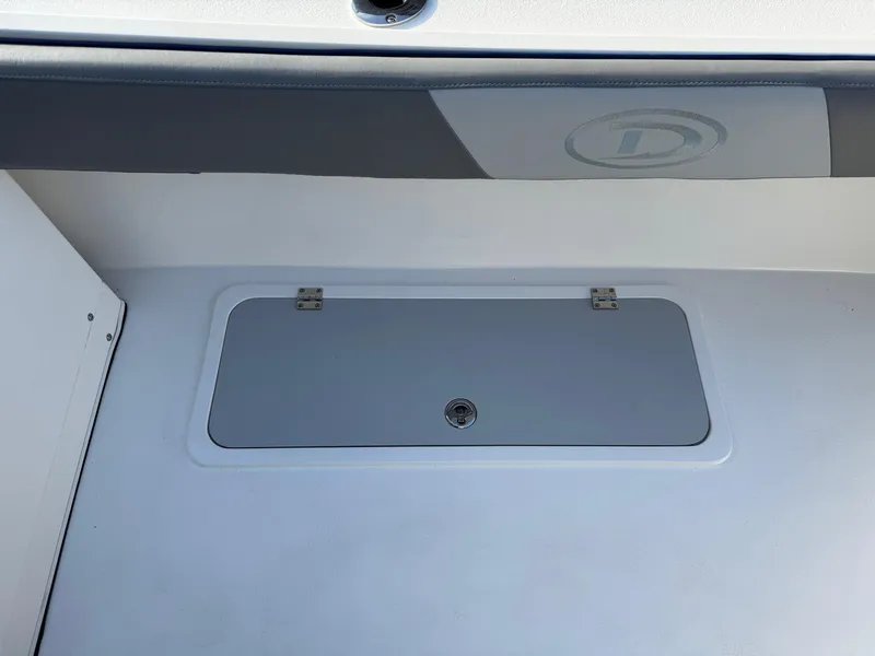 Slide: The Image of 2025 Defiance Admiral 220 EX boat storage compartment with secure latch. - 25