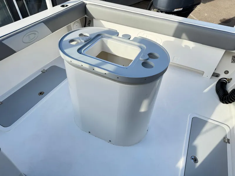 Slide: The Image of 2025 Defiance Admiral 220 EX boat deck with center console and storage compartments. - 26