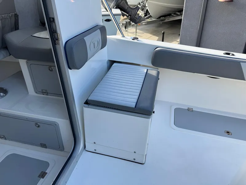 Slide: The Image of Interior of 2025 Defiance Admiral 220 EX boat, featuring seating and storage compartments. - 29